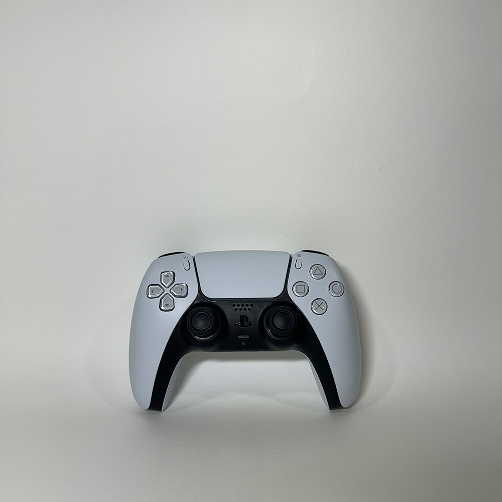 For my photography I set up a large white paper over my dresser and would use an adjustable light to help make sure the shadows weren&rsquo;t too distracting (I would only adjust where the light would come from if the shadows were too harsh). Additionally, I resized all photos taken from my phone onto a 1000x1000 pixel artboard on photoshop to help ensure some amount of consistency. This first photo I just took a photo of the dual sense controller straight on.